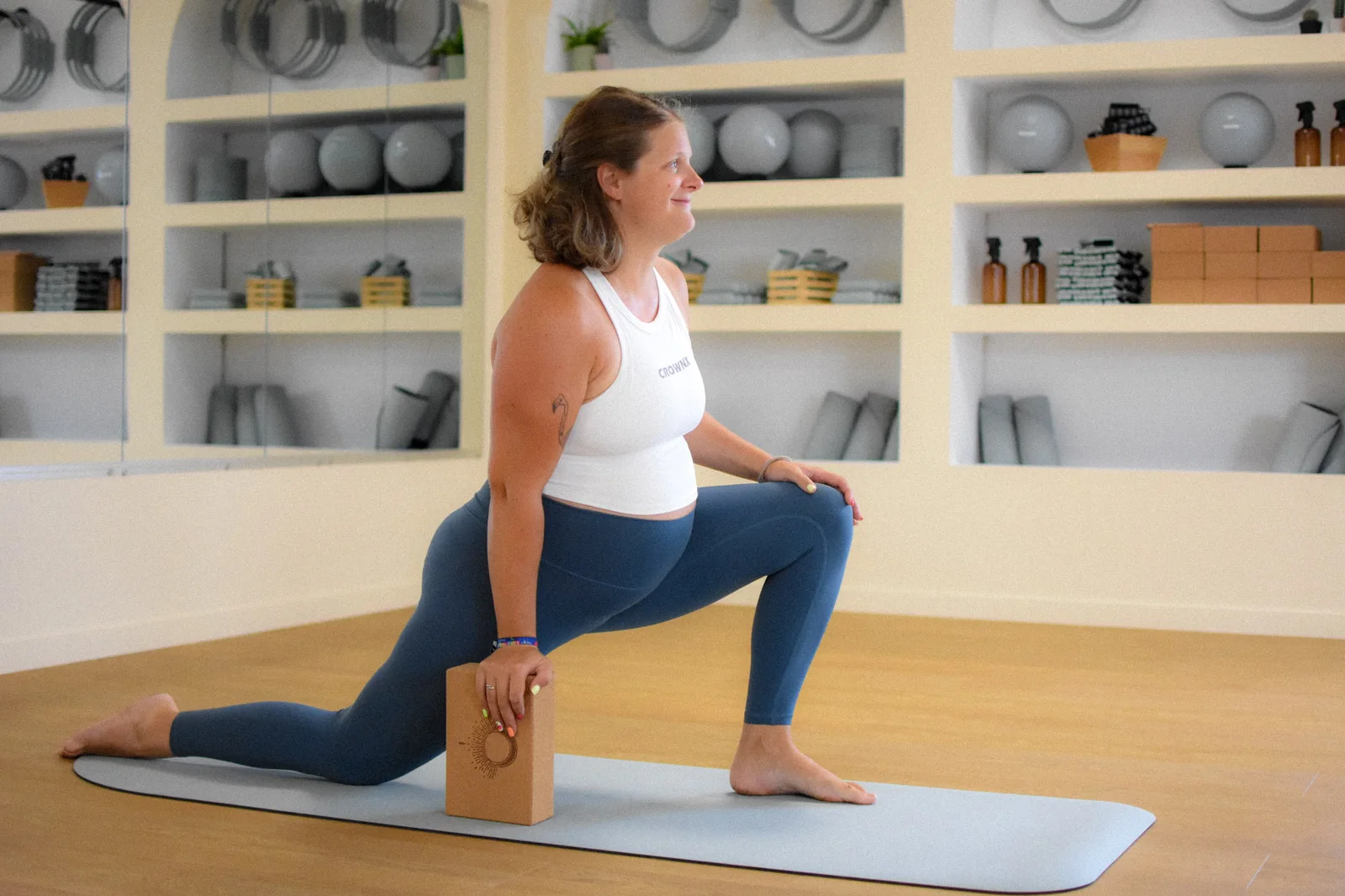Les mains posées sur le ventre, pendant une séance Bloom Pilates.